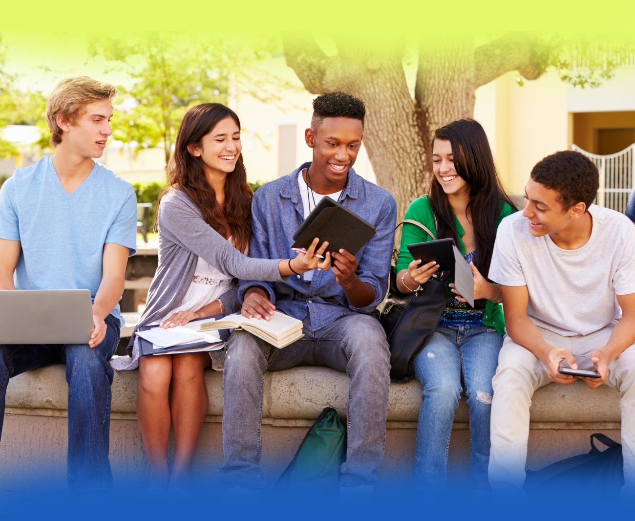 Group of students with electronic devices on bench